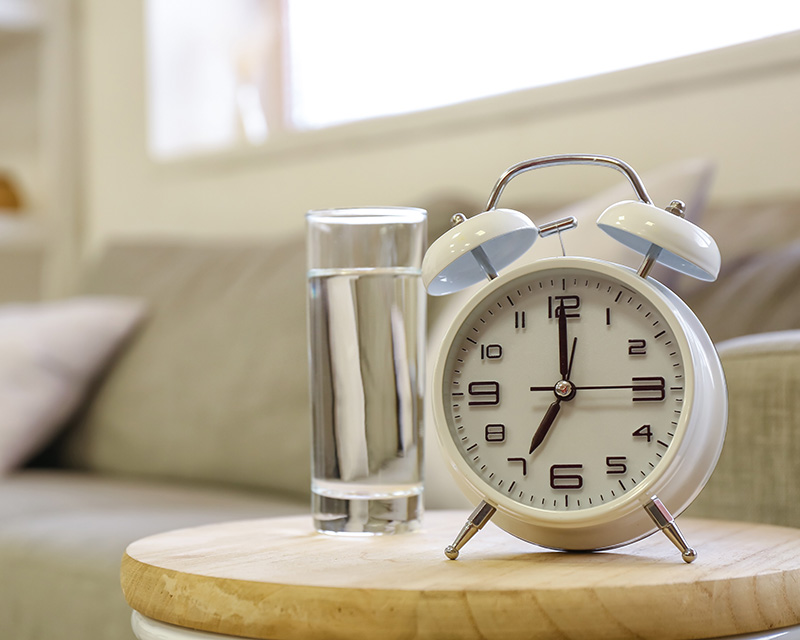 Glass of water and clock for medication management in Fargo, ND